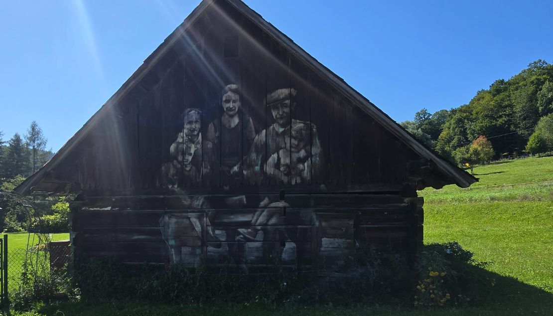 Cichy Memoriał Arkaadiusz Andrejków Zbliżenie na artystyczny deskal stodoły, przedstawiający postacie historyczne.
