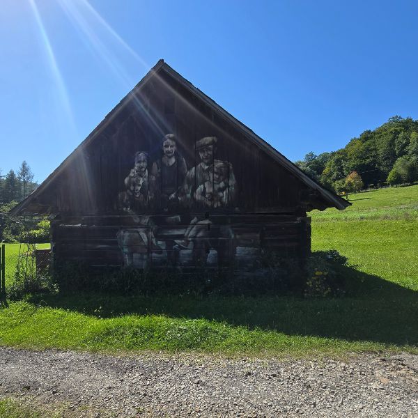 Stara drewniana stodoła w Bieszczadach ozdobiona dużym muralem.